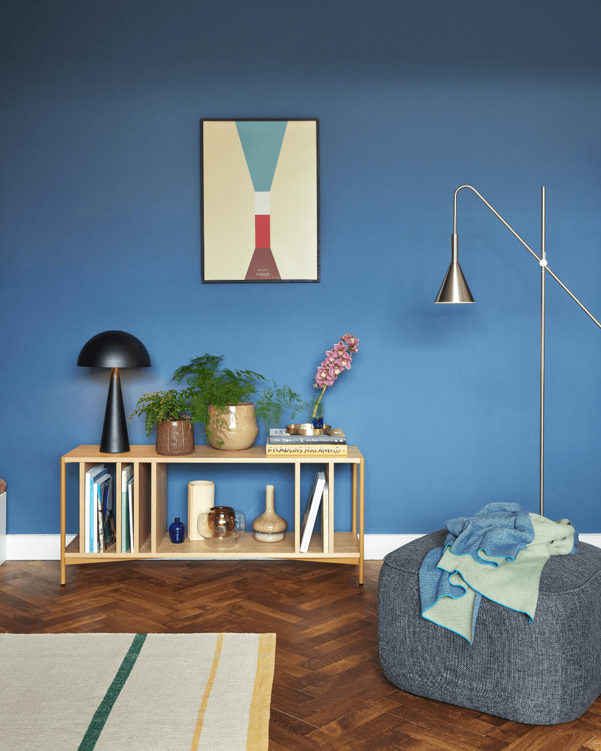 Høj Hubsch bordlampe i sort på reol i farverig stue