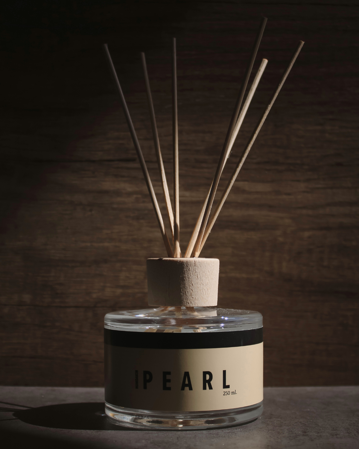 Humdakin Pearl duftpinde i klar flaske med sorte pinde, komfort og frisk aroma