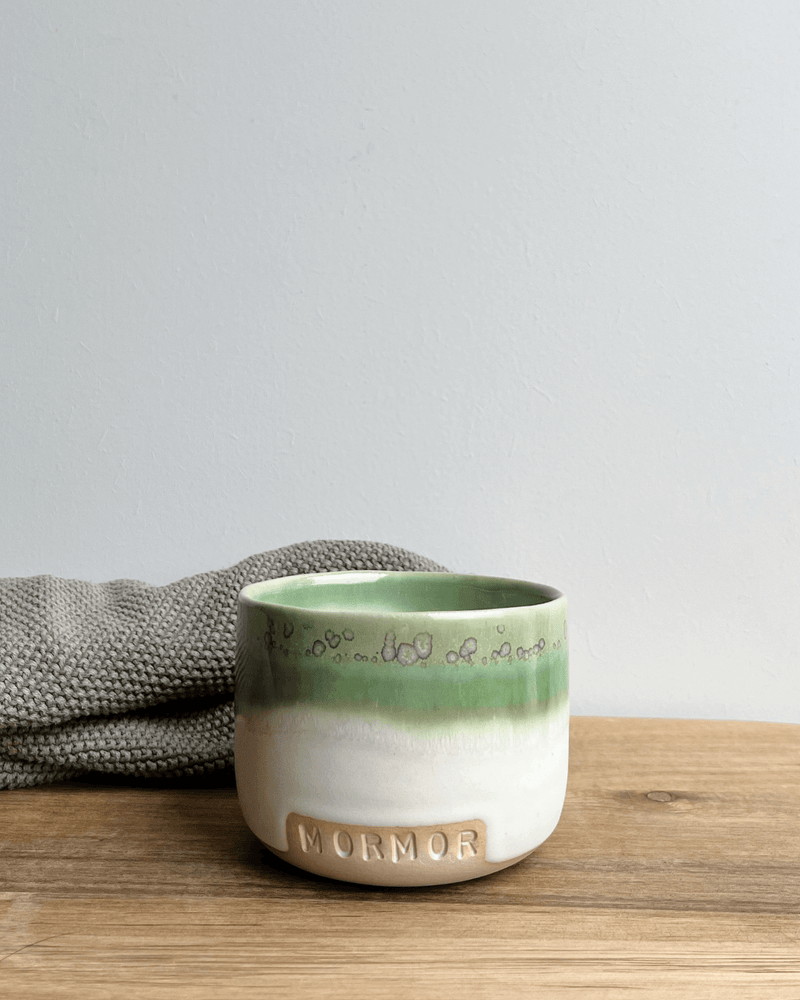 Hvid og grøn keramik kaffekop fra Vaarhus med teksten mormor