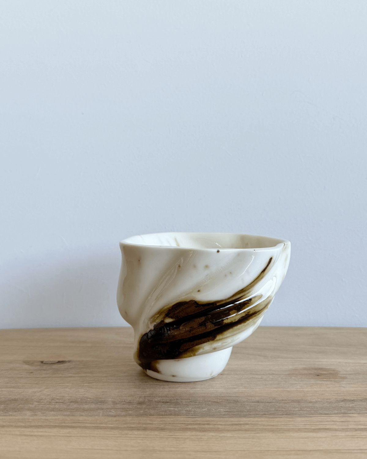 Håndlavet keramik kop fra Studio Aarhus med hvid glasur og brunt penselstrøg