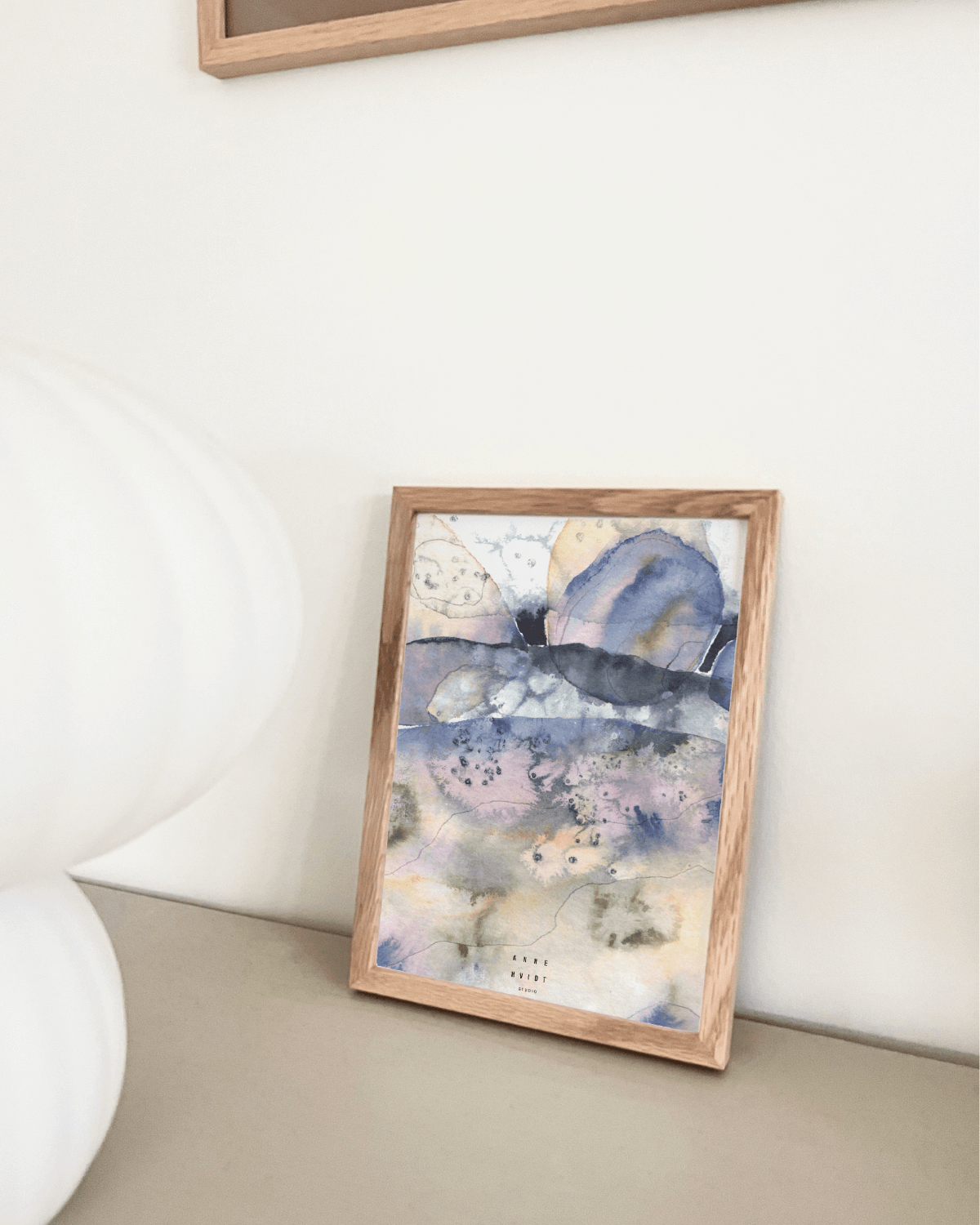 abstrakt motiv med organiske former på art card sat i ramme.