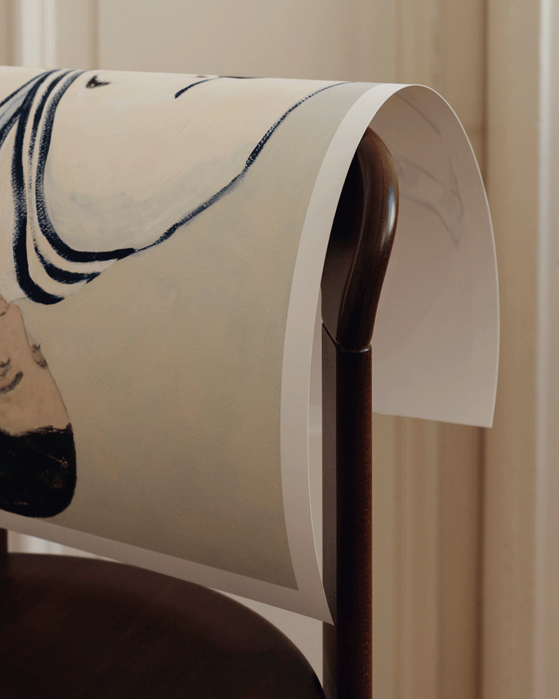 kunsttryk fra the poster club der hænger over stoleryg i spisestue.