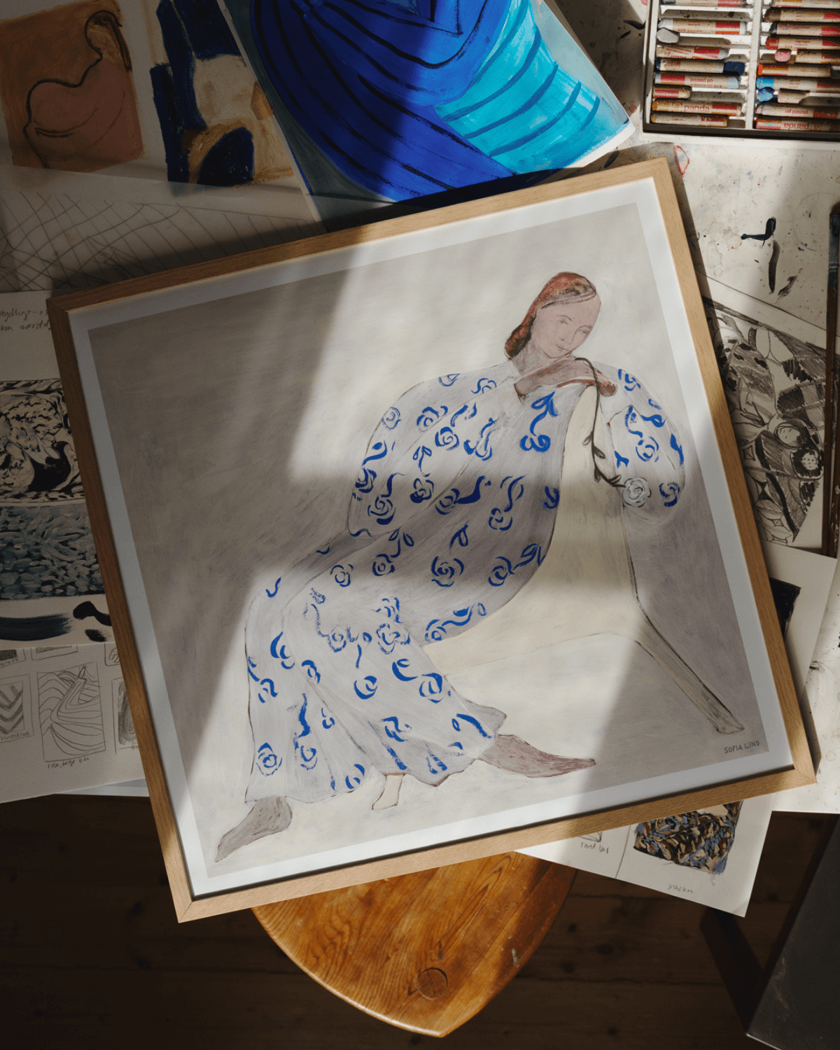 Sofia Linds billede "Rose" i egetræsramme placeret i kreative omgivelser 