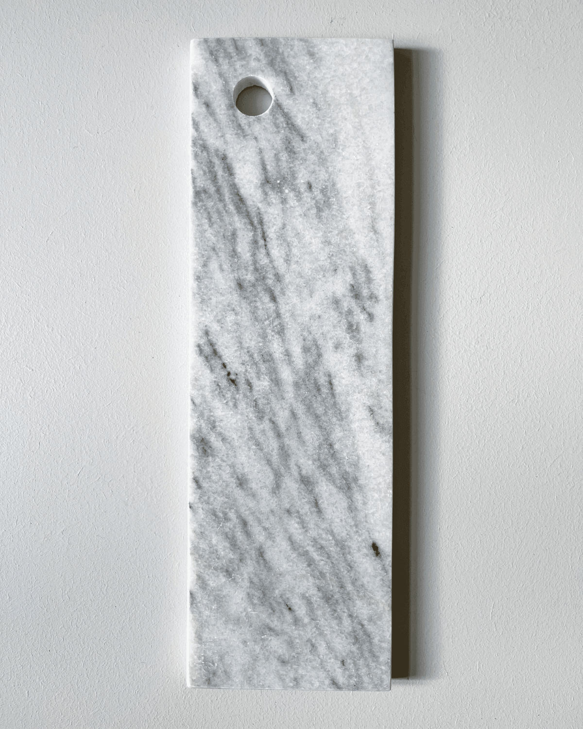 Kontrastfuld marmorplade i hvid med sorte og grå detaljer, perfekt til køkkenet. Smuk plade fra Humdakin