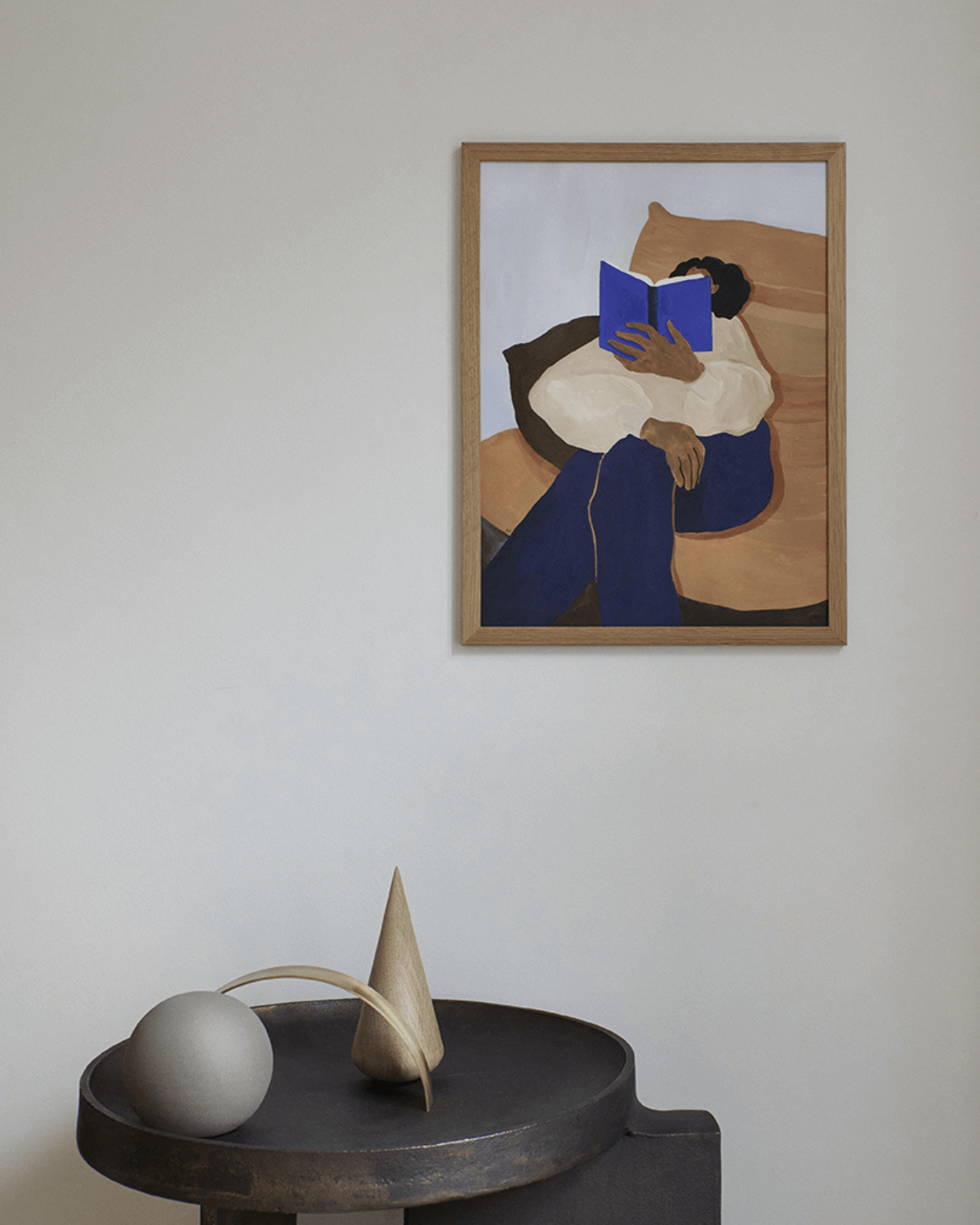 Plakat fra the poster club i ramme på væg bag minimalistisk stilleben. 