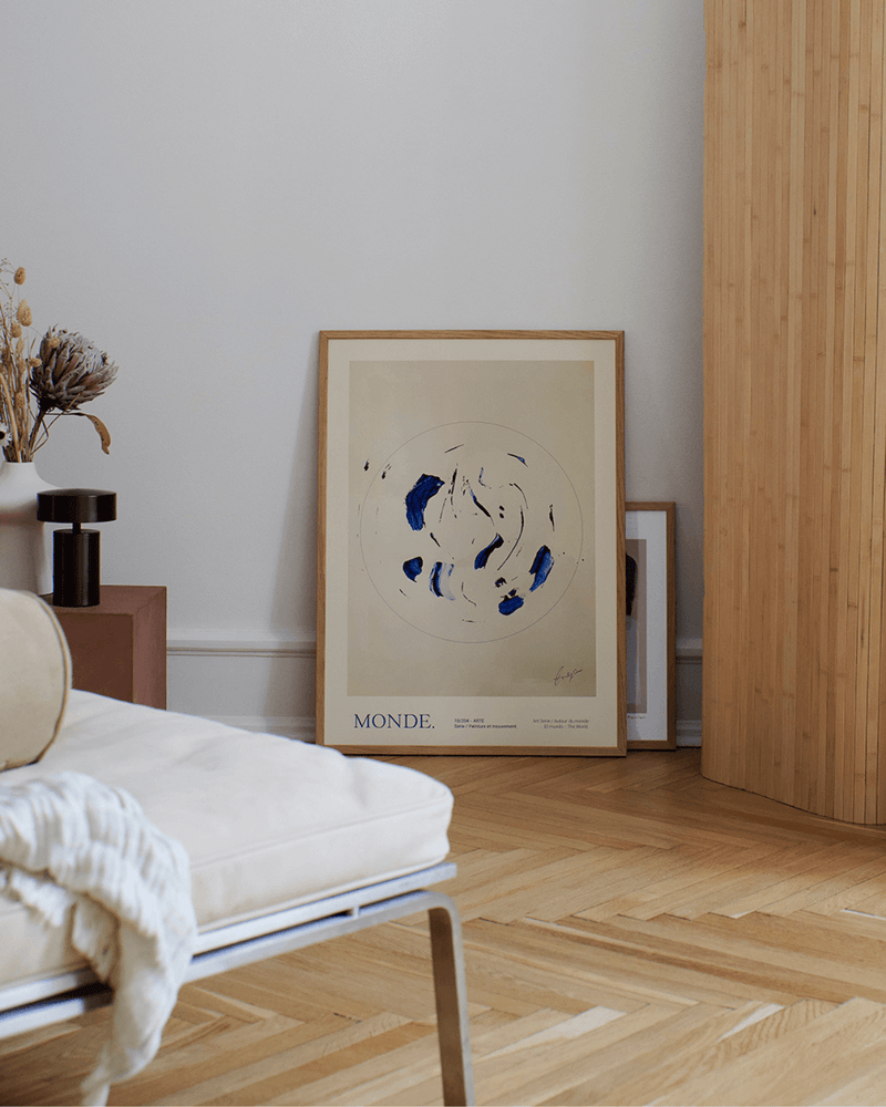 Kunsttrykke Le monde fra the poster club i ramme, hvilende op ad væg i smukt stilfuldt hjem. 