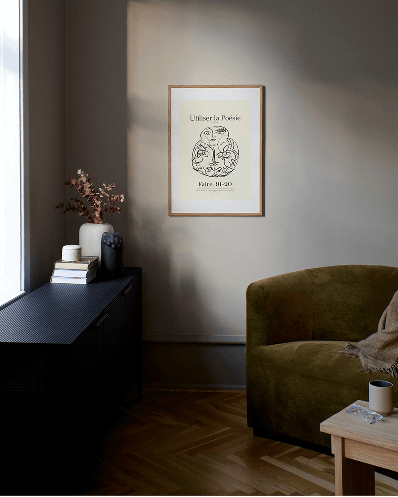 Plakat med enkelt streg motiv, indrammet og placeret i rolige hjemlige omgivelser. 