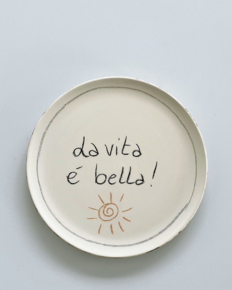 Pizzatallerken i cremefarvet stentøj med teksten “La vita è bella” – håndmalet keramik fra La Gabbianella