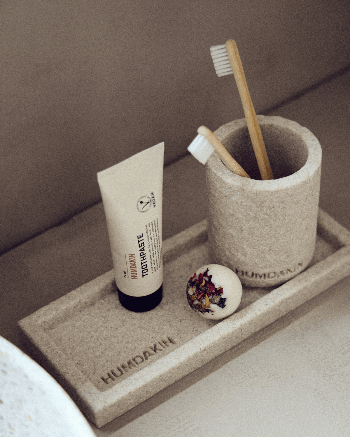 Tandkrus og bakke i lys beige sandsten fra danske Humdakin på nordisk badeværelse 