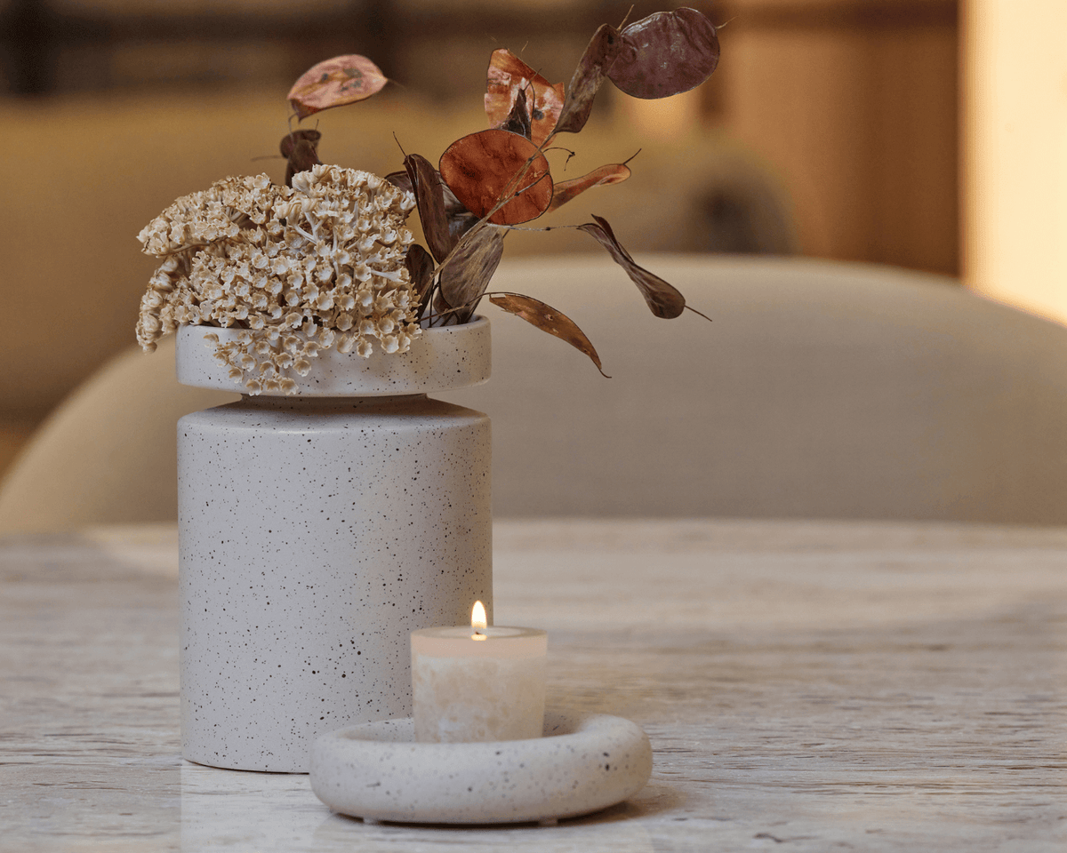 Vase og lysestage fra serien Ania i farven brown mist placeret på spisebord. 