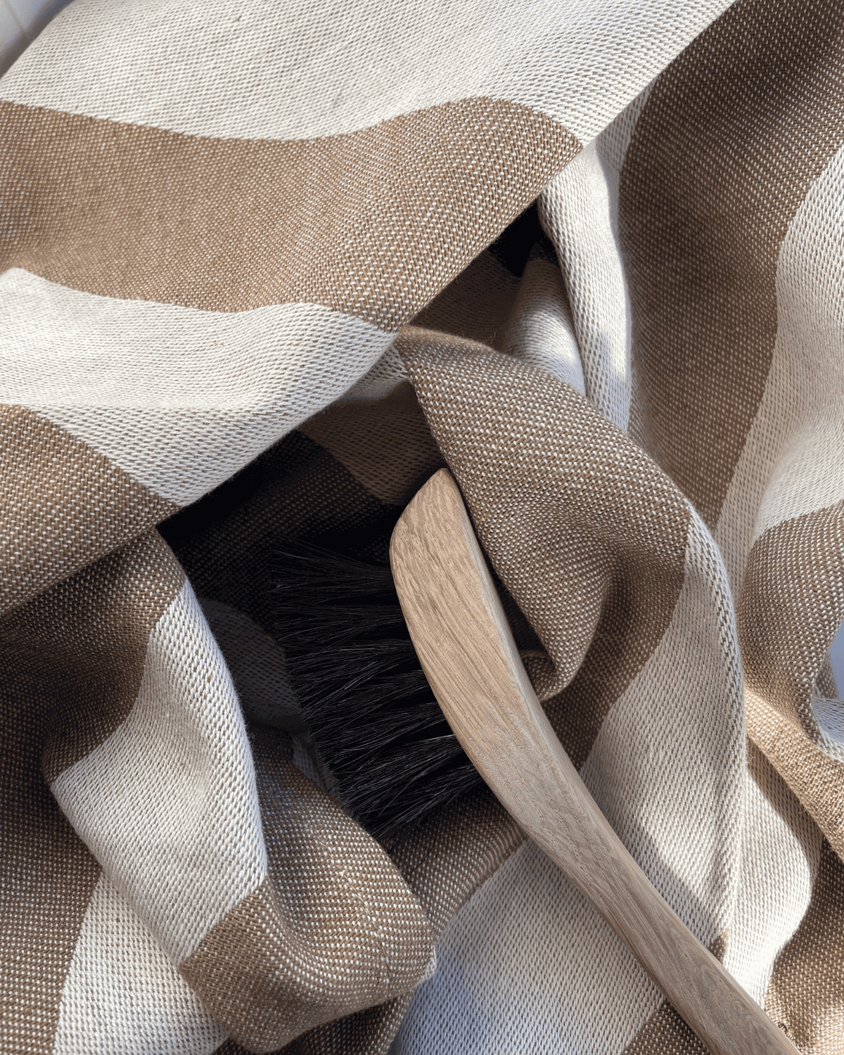 Bredstribet vævede viskestykke i brun og hvid, perfekt til at sætte et luksuriøst præg på sit køkken. 